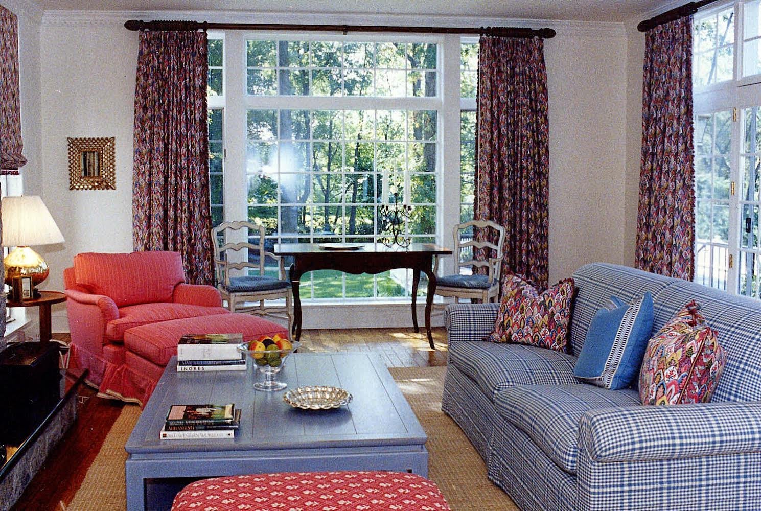 Family living room with a coral chaise, a plaid sofa, and a sunny bay window