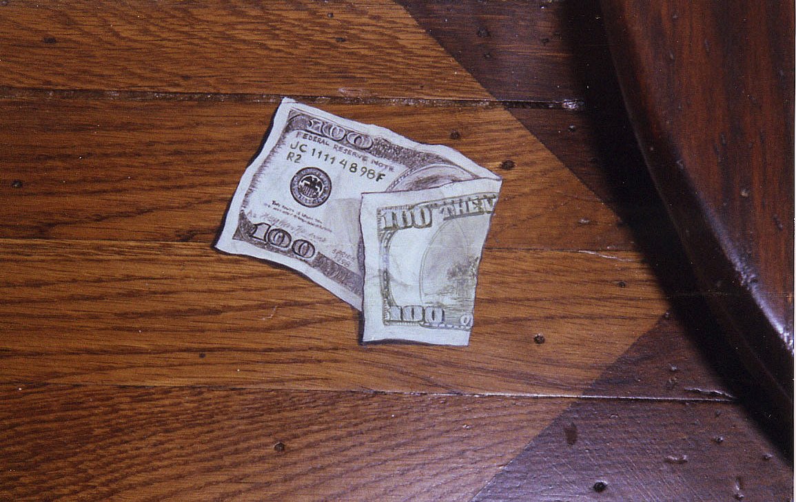 Trompe l'oeil hundred-dollar bills painted onto a hardwood floor as a playful detail