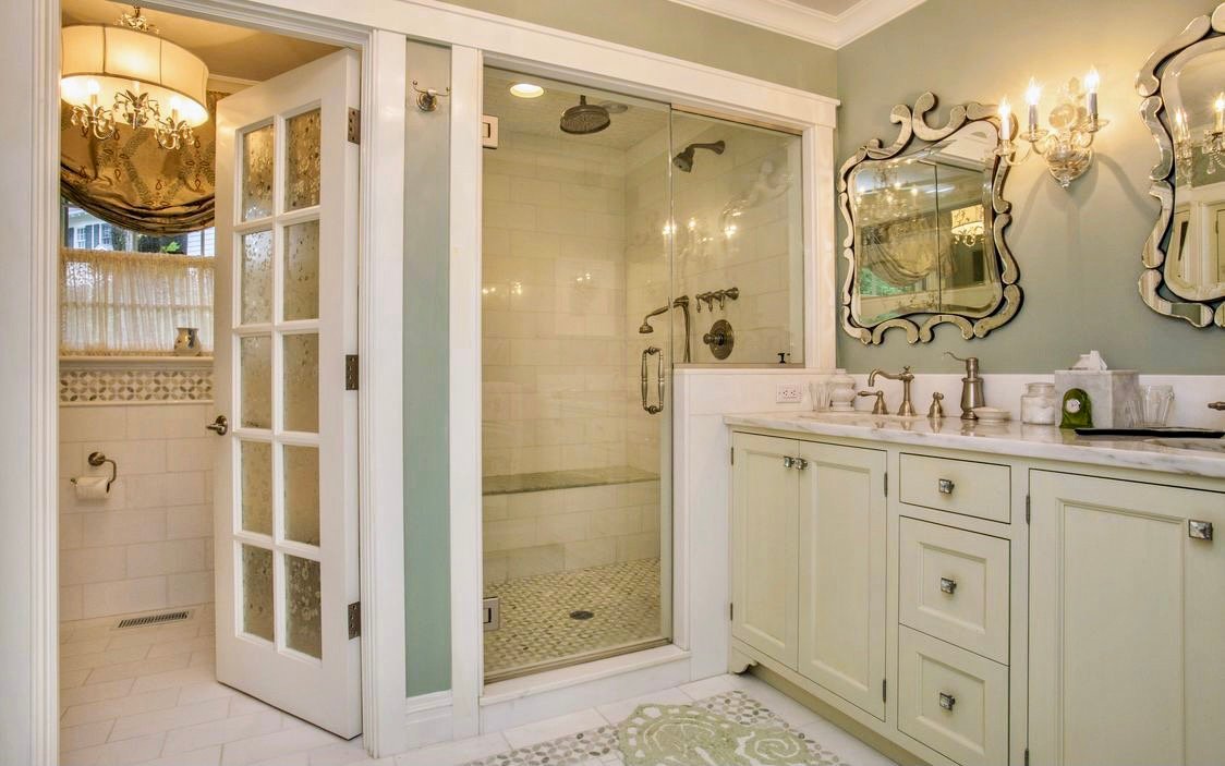 Spa-like primary bath with a glass steam shower, a marble vanity, and Venetian mirrors
