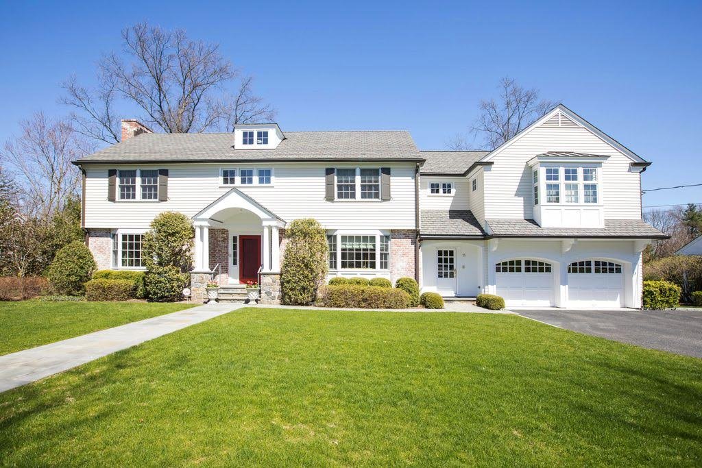 Classic white Colonial home with black shutters and a red front door